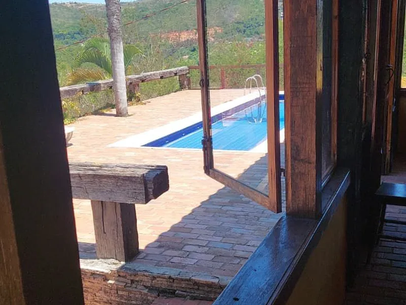 Quarto com cama arrumada, televisão e armário