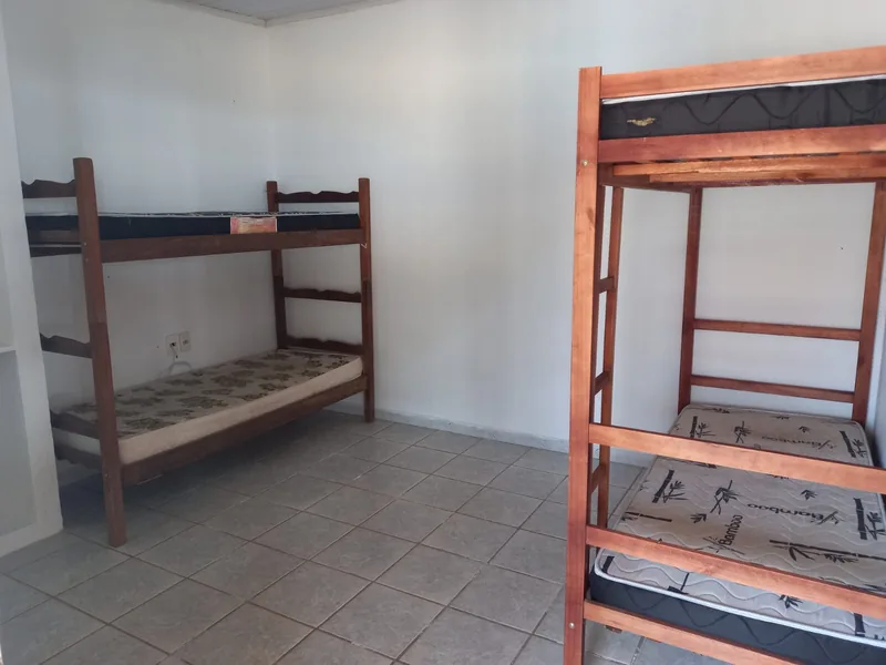 Sala com aparelhos de musculação sob cobertura, aberta para o verde